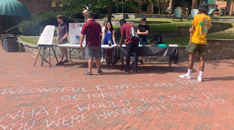 Innocence Club members tabling and chalk message on bricks