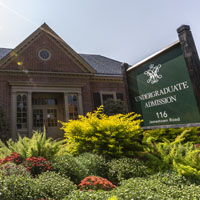 A sign saying undergraduate admission sits in front of a brick building