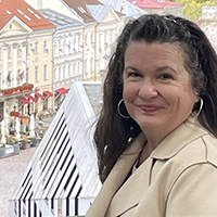 Dawn Edmiston stands on a balcony with picturesque cobblestone street below