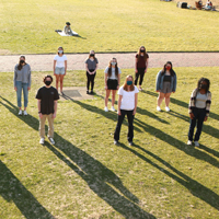 A group of masked students standing outside