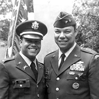A black and white photo shows two people in military uniforms