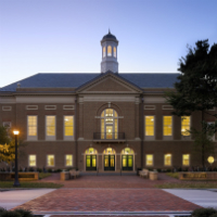 W&M's Raymond A. Mason School of Business with windows lit at dusk