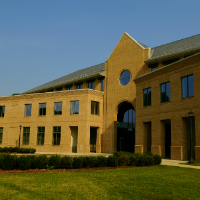 The school of education's entrance with bushes nearby