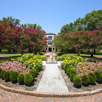 The sundial garden in front of Swem with flowers and trees blooming in multiple colors