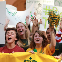 Students holding banners and signs cheer
