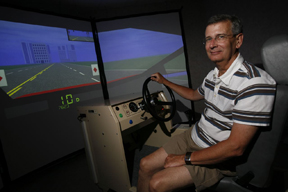 Lou Rossiter, Director, Community Research shows off driving simulator used to provide Williamsburg area residents free driving evaluations. Photo credit: Stephen Salpukas, College of William and 玛丽.