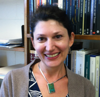 Cristina Stancioiu standing in front of a bookshelf