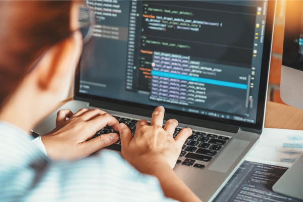 Woman working on laptop with code