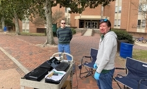 Danny Clouser (left) and Brandon Bell (right) work to distribute loaner laptops to William & 玛丽 employees in front of Morton Hall.