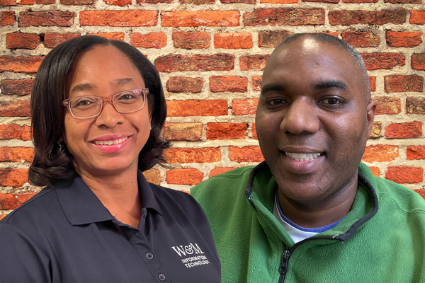 Shewlyn Chen-Stewart and Louis Hubert in front of a brick wall.