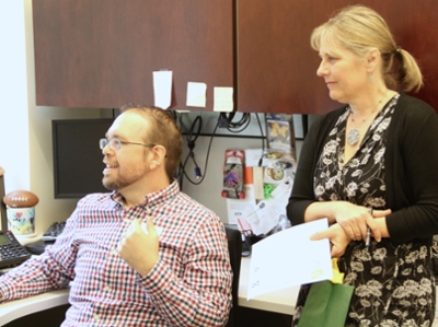 Daniel Norton demonstrates classroom technologies to Julie Hummel, Associate Director, Program Development, at the Mason School of Business