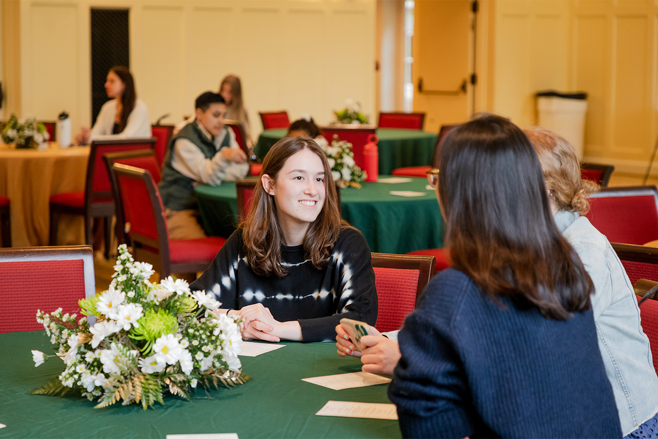 A group of people sitting and talking at a table.
