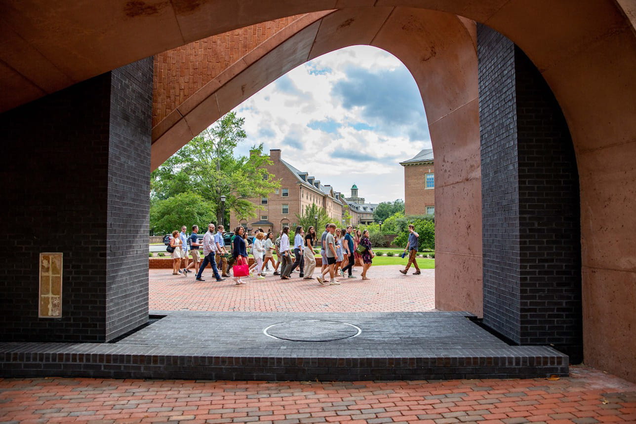 A group of students and their families in a group tour of campus, with William & 玛丽 Memorial to the Enslaved in the foreground
