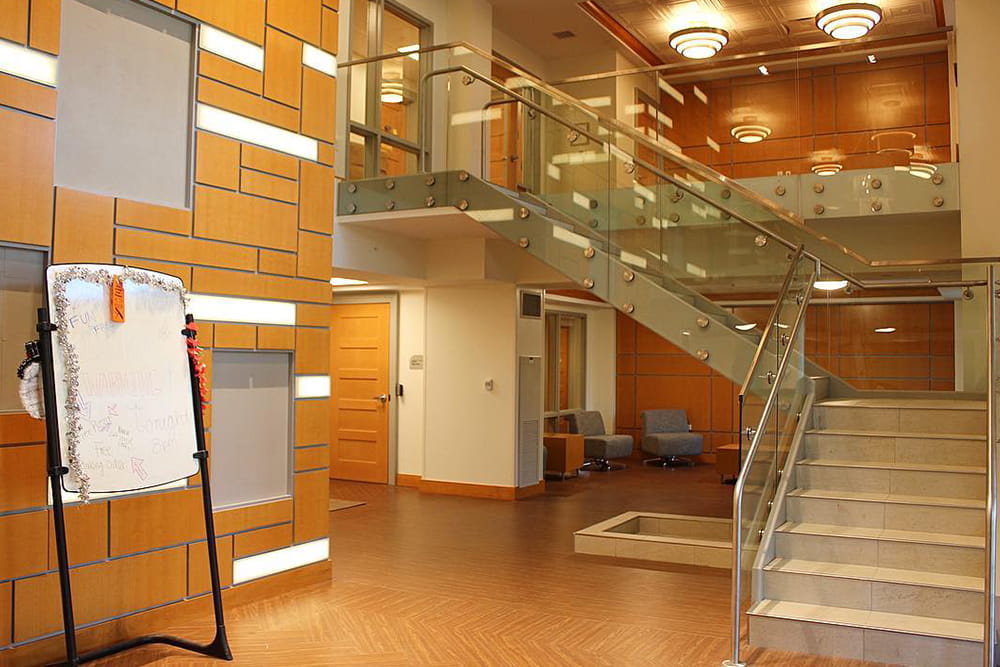 Modern two-story interior with glass staircase and seating areas