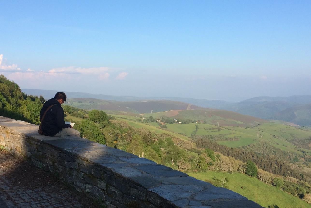 William & 玛丽 student sitting down on a wall at el Camino de Santiago